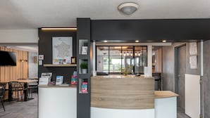 Un área de recepción de diseño moderno, que incluye un mostrador de recepción, zona de estar y un mapa en la pared.