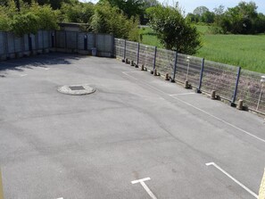A parking lot with marked spaces and a manhole cover. - Brit Hotel Iroise (Plougastel-Daoulas)