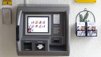 Ein Selbstbedienungsterminal mit Bildschirm, der verschiedene Sprachen anzeigt, und einem Tastaturfeld.