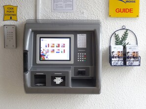 A self-service kiosk with a screen displaying various languages and a keypad. - Brit Hotel Iroise (Plougastel-Daoulas)