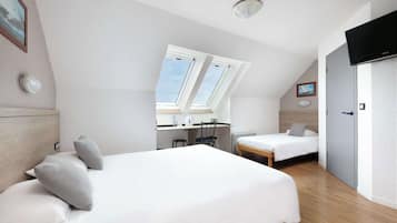 Une chambre moderne avec un grand lit, un bureau et une télévision.