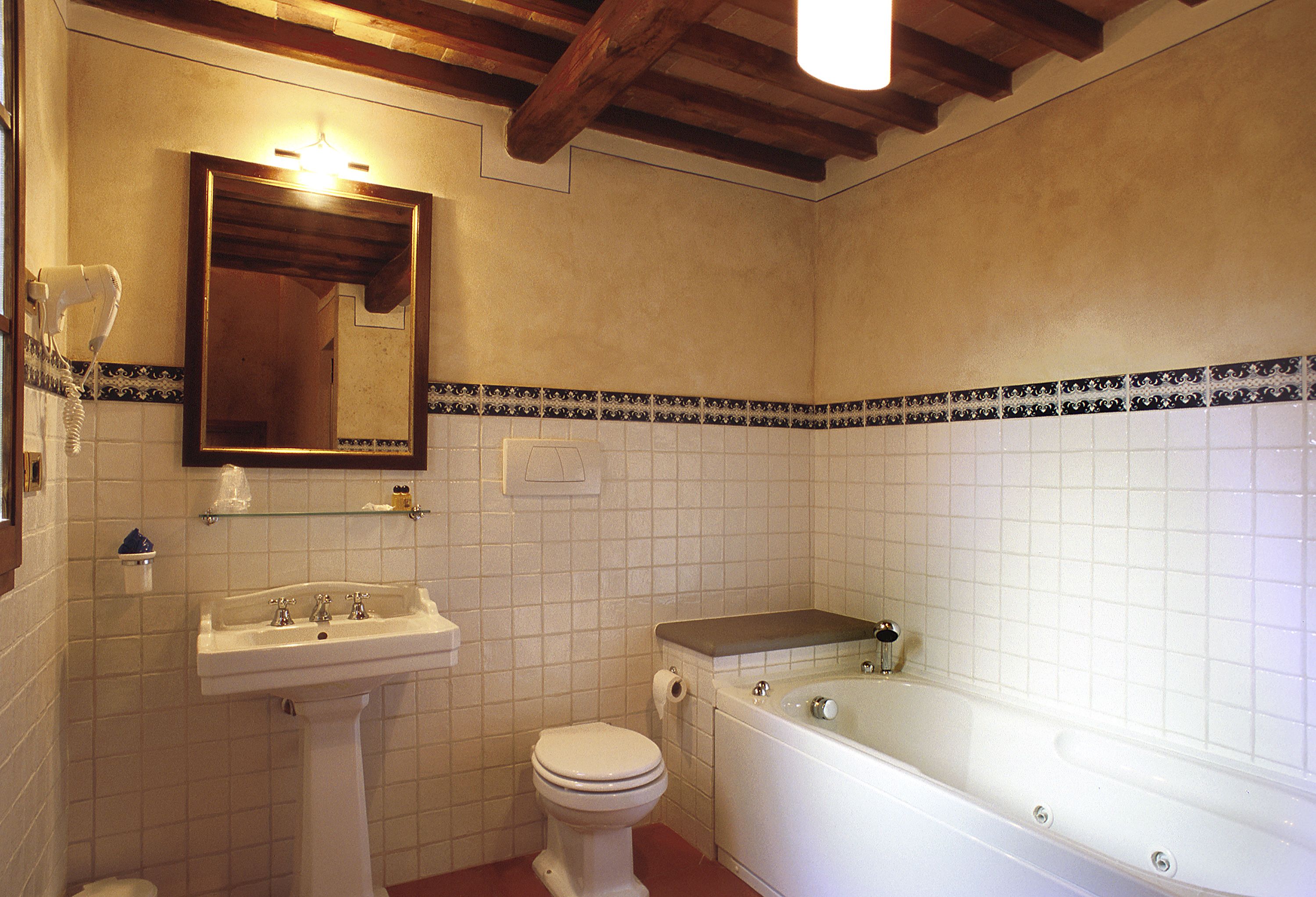 Une salle de bain avec un lavabo sur colonne, des toilettes et une baignoire.