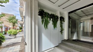A hotel entrance with a modern design, featuring a glass door, a staircase leading inside, and a wall with a logo. - Puerto Azul (Puerto de la Cruz)