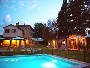 Una piscina al aire libre, sombrillas, tumbonas
