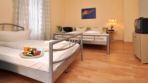 A hotel room with two beds, a television, a lamp, and a painting on the wall. - Apadana Hotel (FRANKFURT AM MAIN)