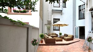 A courtyard with outdoor furniture, a ladder, and potted plants. - Apadana Hotel (FRANKFURT AM MAIN)