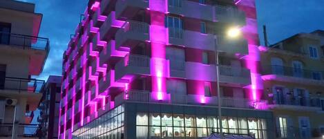 Een meerhoog hotel met balkons en een bordje waarop 'PALACE HOTEL' staat.