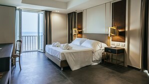 A modern hotel room with a large bed, bedside table, desk, and chair. - Hotel Palace (Catanzaro)