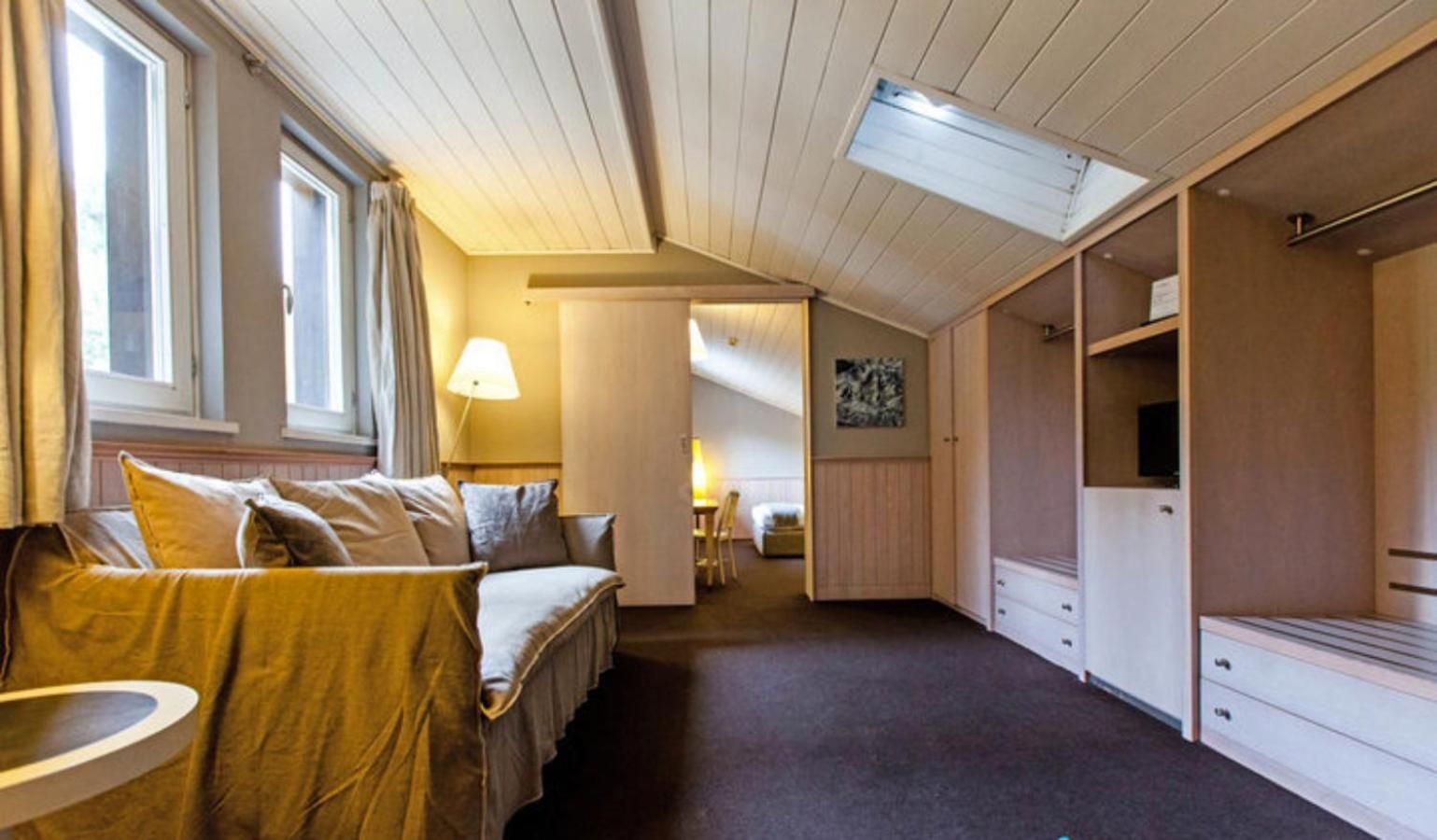 A room with a bed, a desk, and a wardrobe.