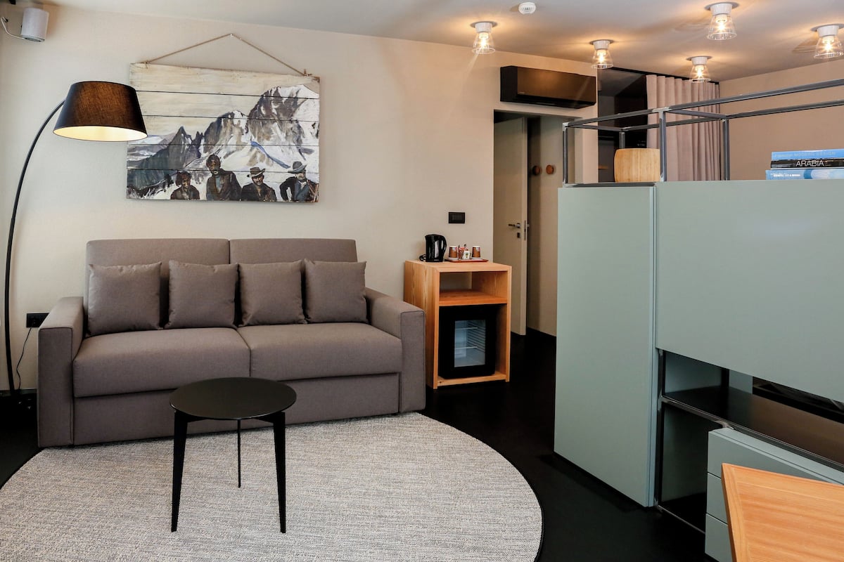 Habitación cuádruple Deluxe | Área de sala de estar | Televisión de pantalla plana de 18 pulgadas con canales digitales