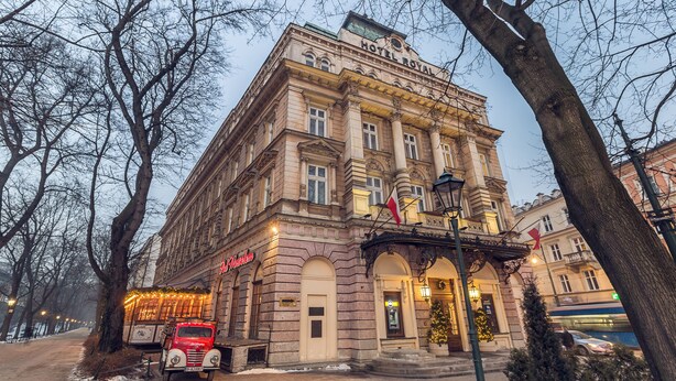A historic building with a classic architectural style, featuring a prominent entrance with a balcony and a sign that reads "HOTEL ROYAL." - Hotel Royal (Kraków)