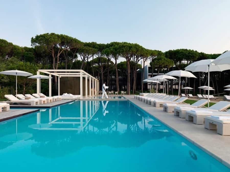 Una piscina al aire libre, sillones reclinables de piscina