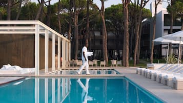 Una piscina al aire libre, sillones reclinables de piscina