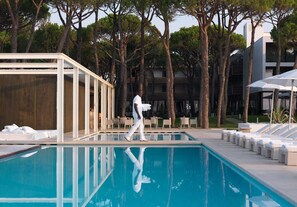 Una piscina al aire libre, sillones reclinables de piscina