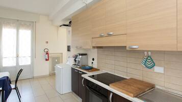A modern kitchen with wooden cabinets, a black stove, and a white countertop.