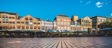 Una plaza pavimentada con edificios al fondo.