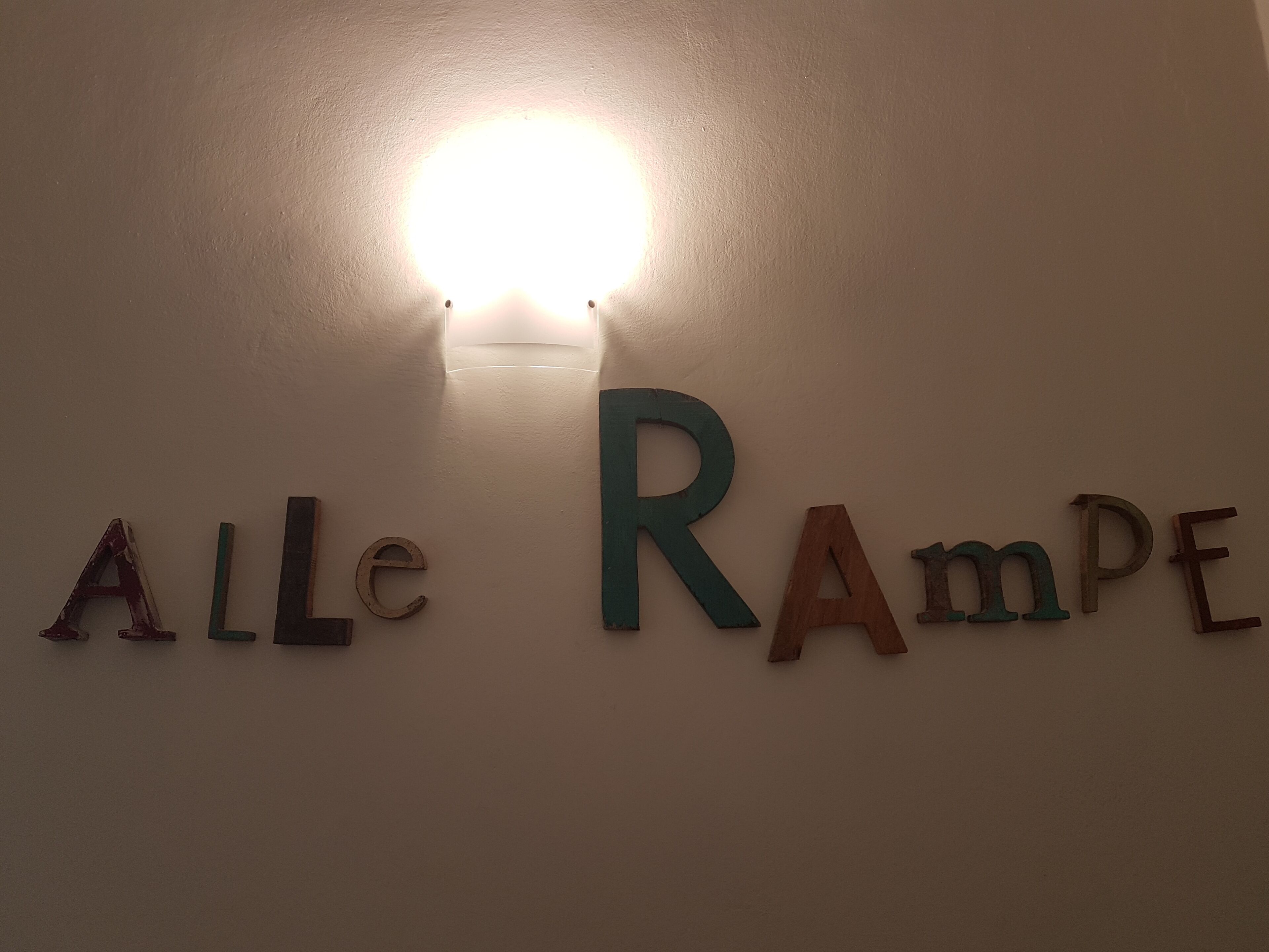 A wall with the name "ALLE RAMPE" spelled out in wooden letters.