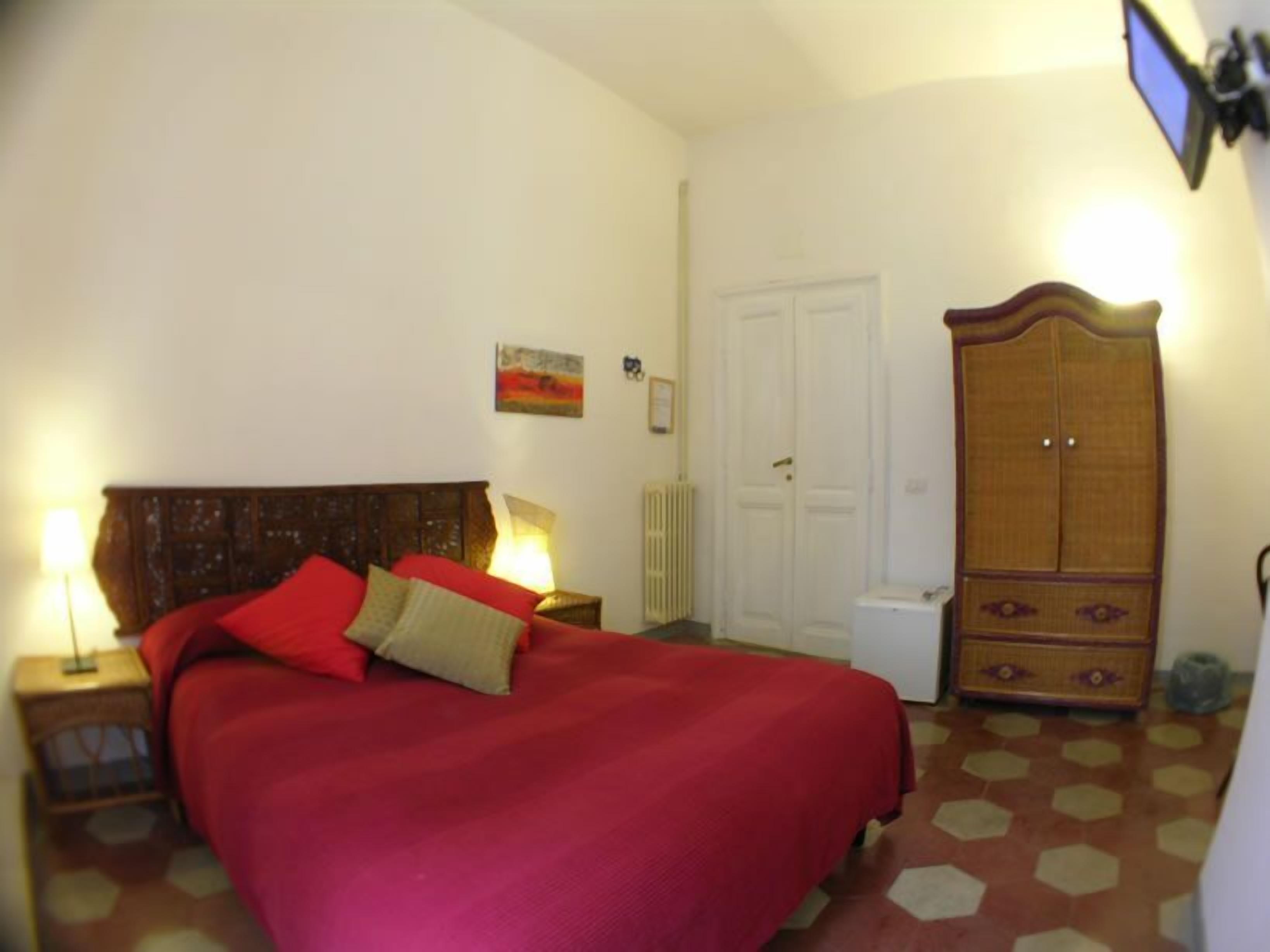 Un dormitorio con cama, armario, radiador y una puerta.