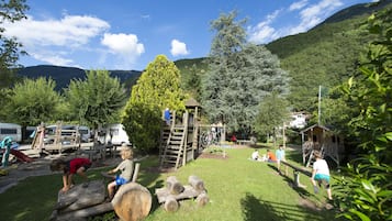 A playground with wooden structures, a slide, and a climbing net.
