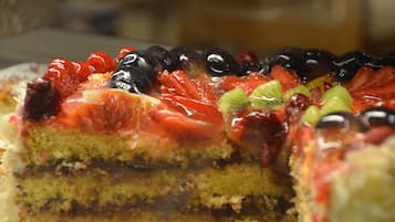Una porció de pastís amb diverses capes i coberta amb fruita.