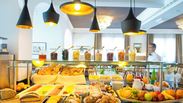 Een ontbijtbuffet met diverse gerechten en dranken, zoals fruit, gebak en ontbijtproducten.