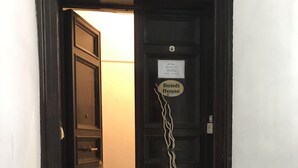 A dark wooden door with a sign reading "Bundi House" and a welcome mat at the entrance. - San Daniele Bundi House (Rome)