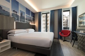 Een moderne hotelkamer met een groot bed, een bureau met stoel, en een stadsgezicht muurschildering.
