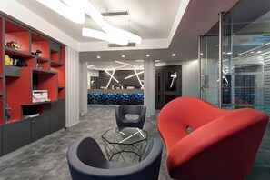 A modern office space with a reception desk, two chairs, and a glass partition. - iQ Hotel Milano (Milan)