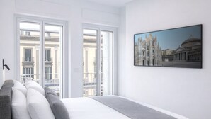A modern bedroom with a large bed, a cityscape view, and a framed picture on the wall. - Fiorentini Residence (Naples)