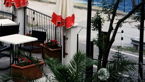 A seaside hotel sign with a view of sailboats on the water. - Hotel Oasi Beach (Malcesine)