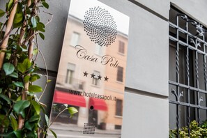 Señal de hotel con el nombre "Casa Poli" y una dirección web.