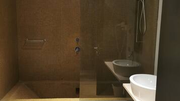Un bagno con doccia vetrata, lavandino bianco e vasca da bagno.