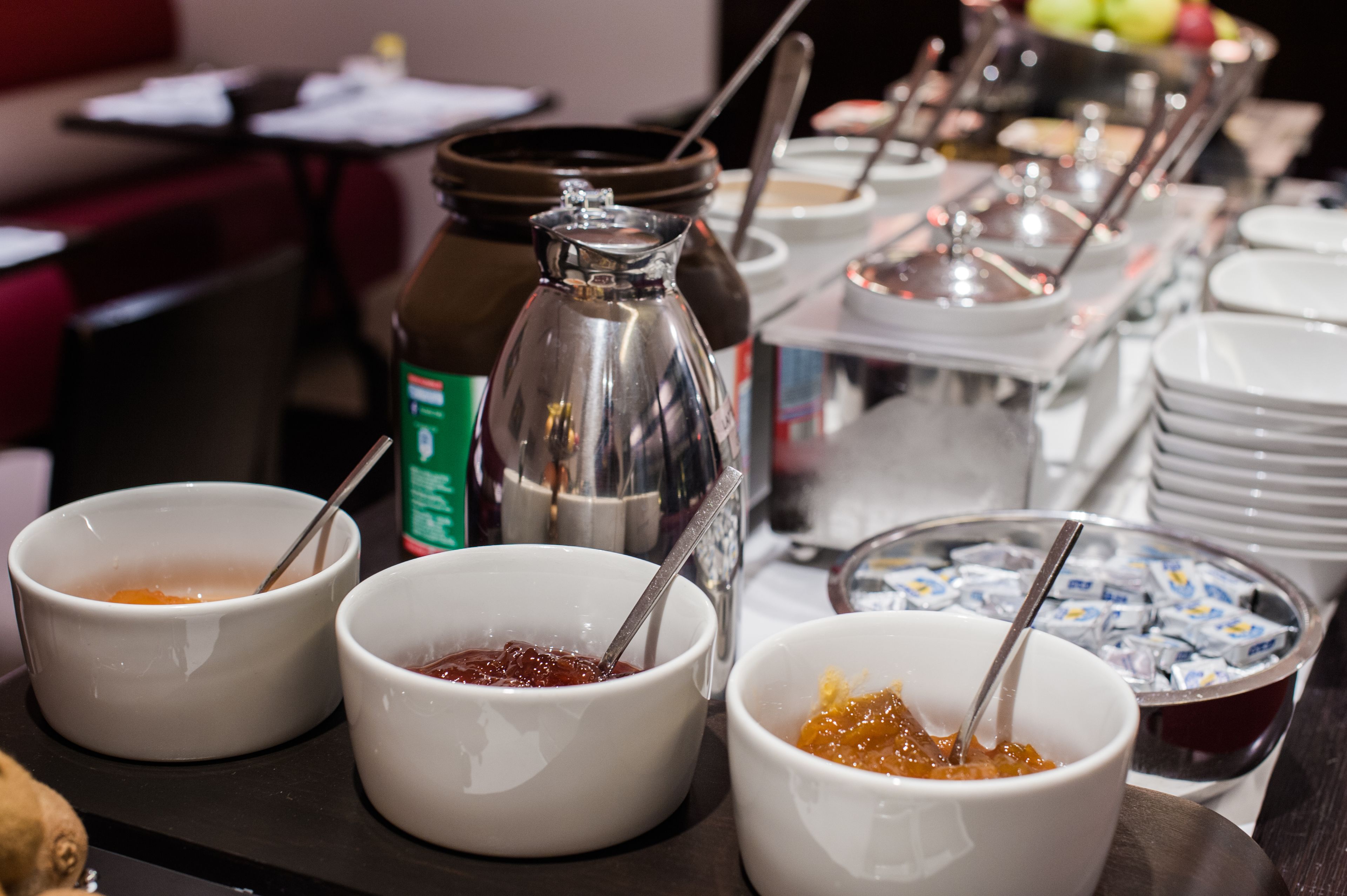 Una mesa de buffet con diversos alimentos y salsas.