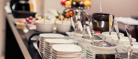 A buffet setup with various food items and utensils.