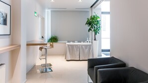 A modern hotel lobby with a reception desk, seating area, and a large window providing natural light. - Hotel Casa Poli (Mantua)