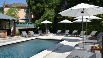 Een seizoensgebonden buitenzwembad en parasols bij het zwembad