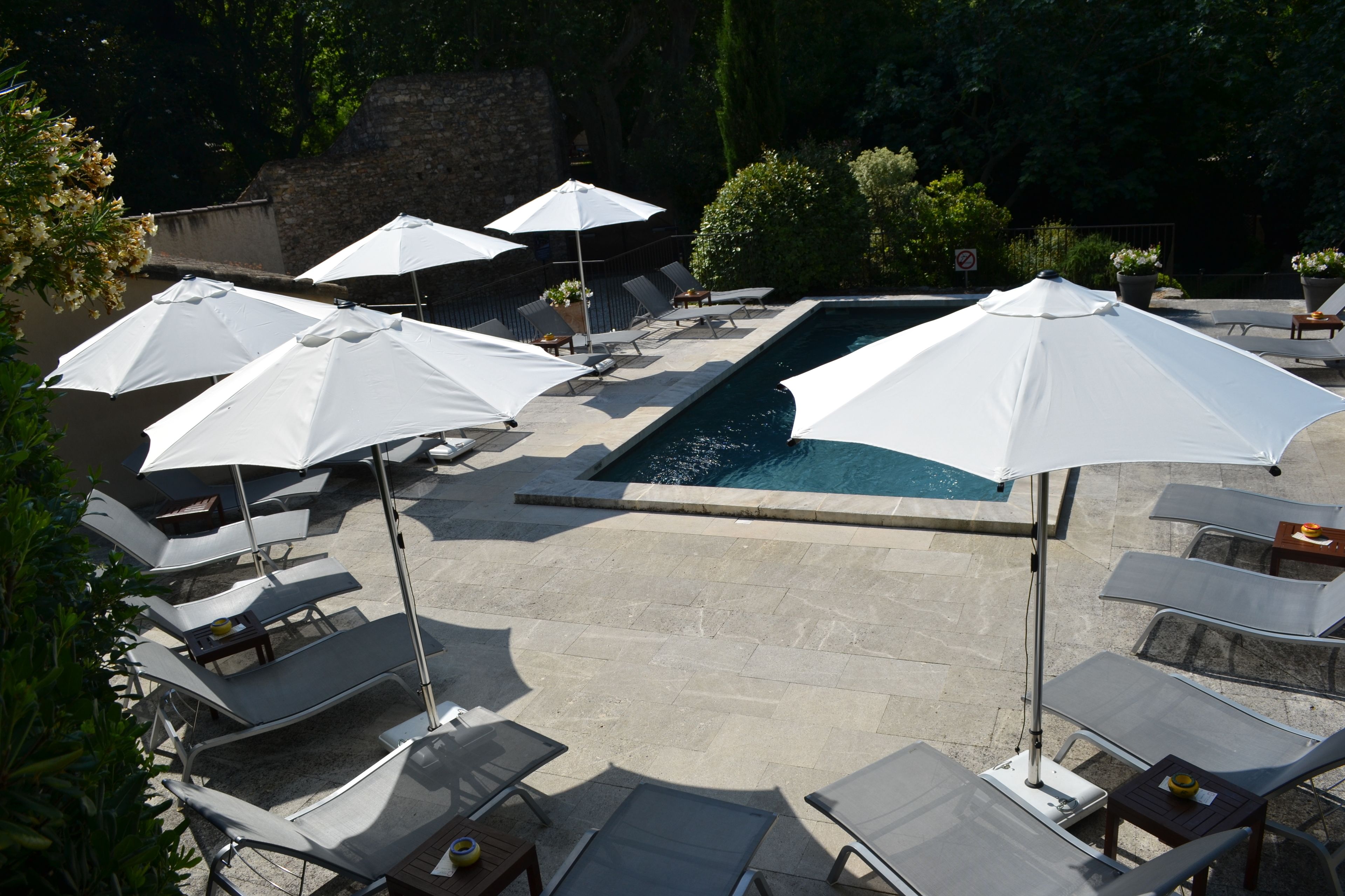 Ein Poolbereich mit Liegestühlen und Sonnenschirmen.