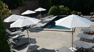 Ein Poolbereich mit Liegestühlen und Sonnenschirmen.
