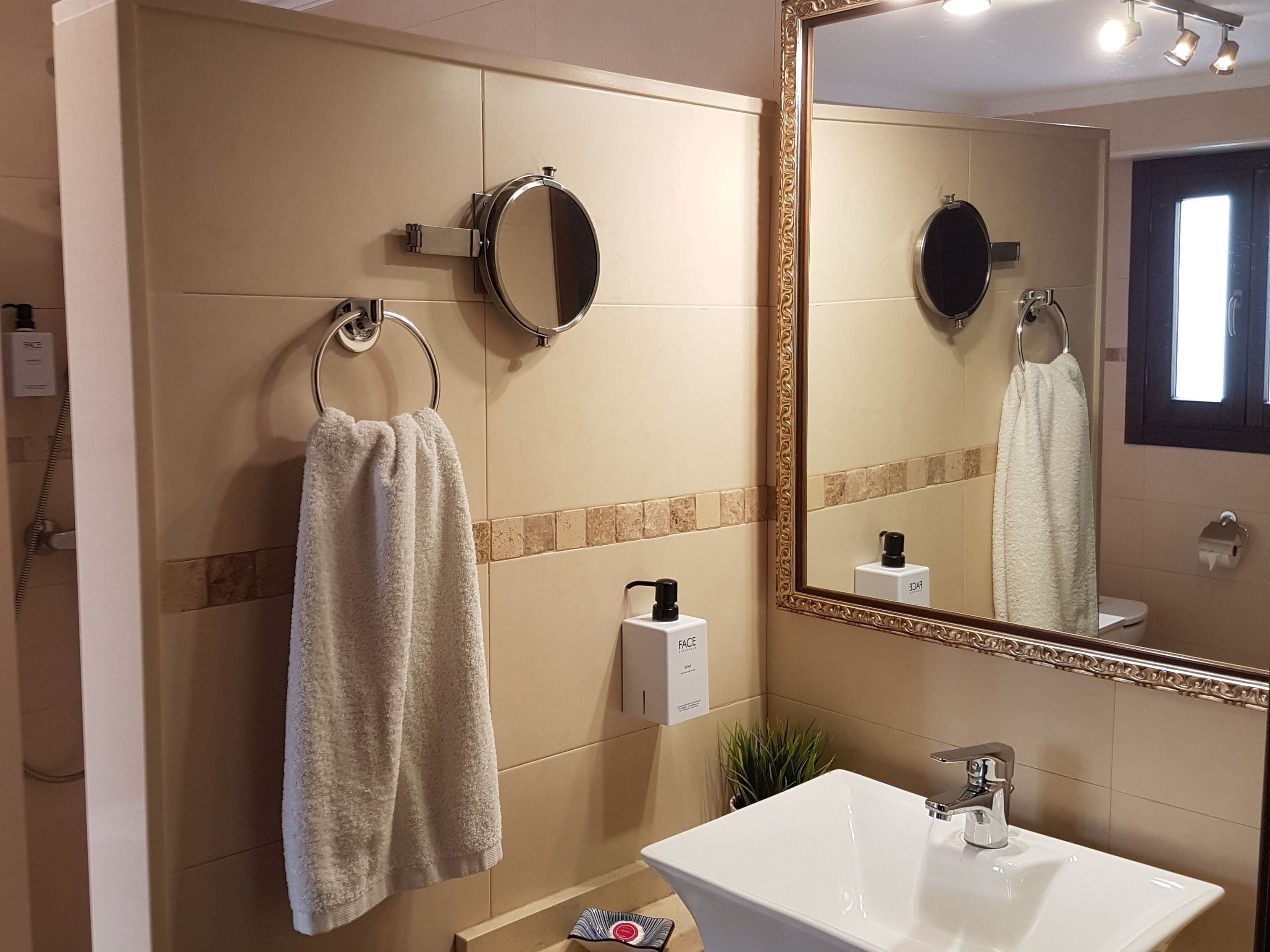 Ein Badezimmer mit Waschbecken, großem Spiegel und einem Handtuch an einem Halter.