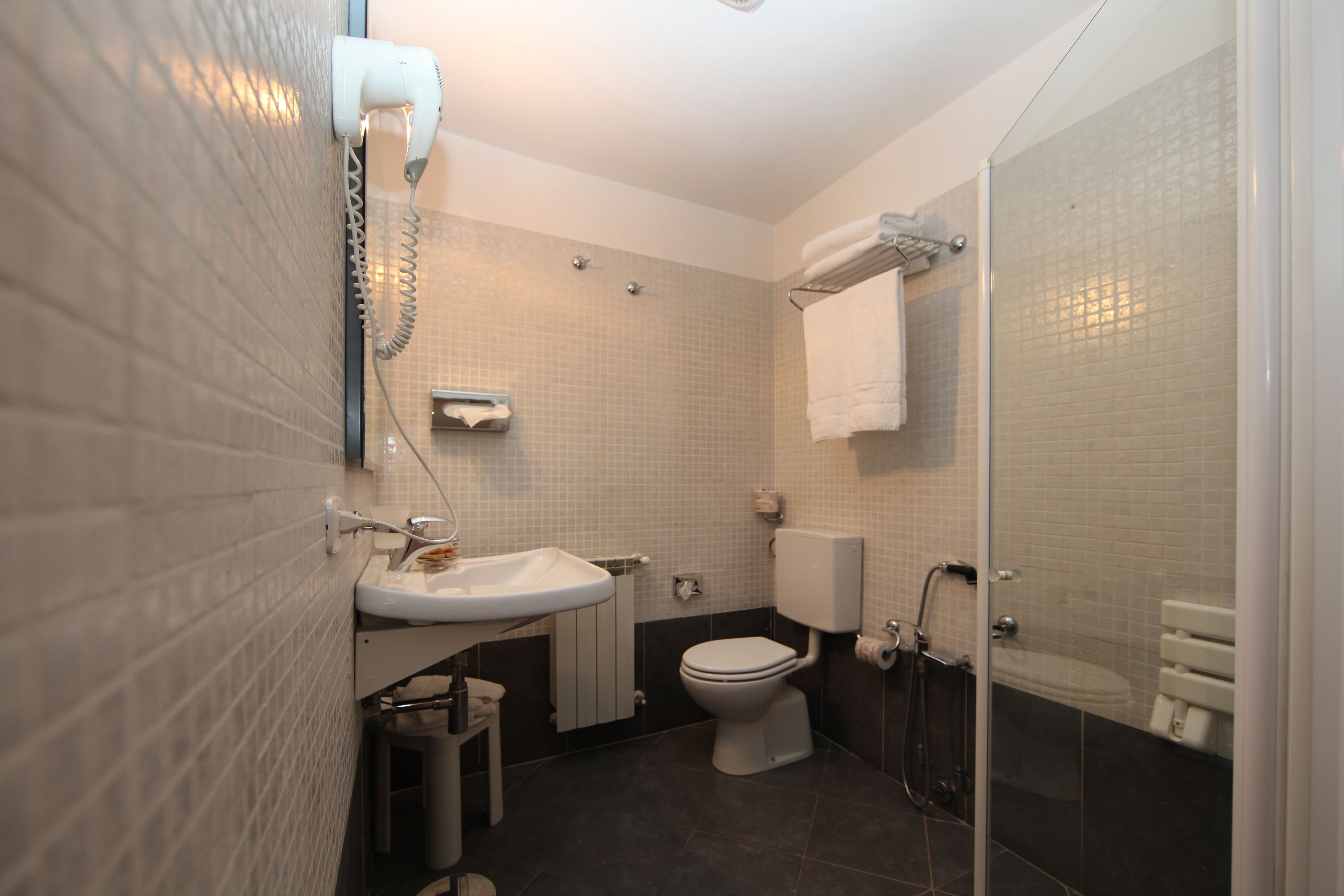 A modern bathroom with a sink, toilet, and shower.