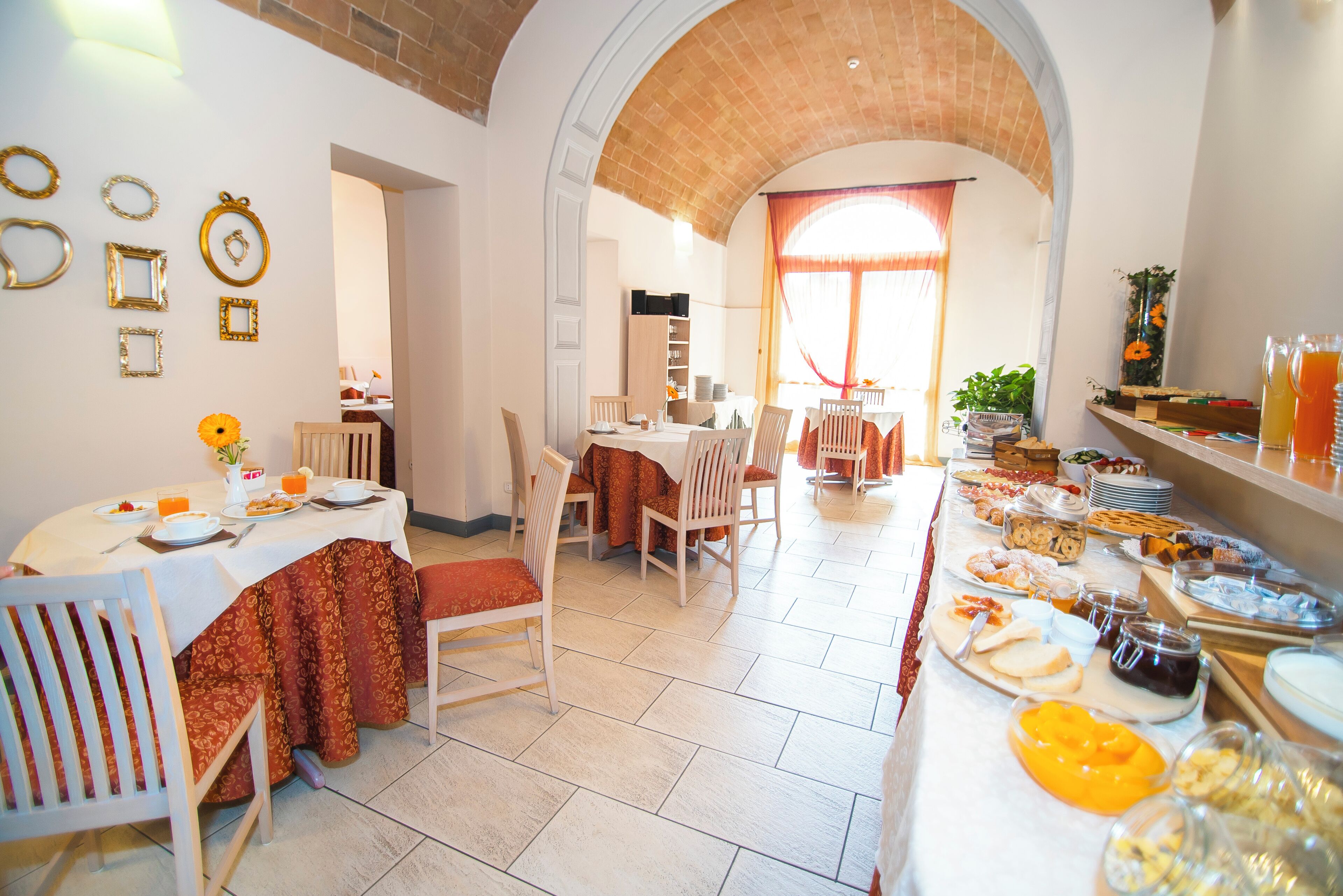 Un'area ristorazione con buffet, sedie e tavolo apparecchiato per la colazione.