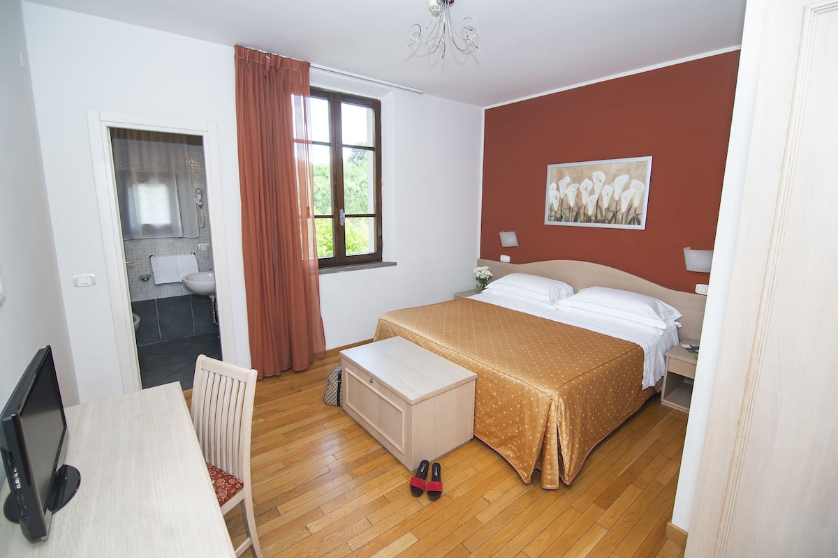 A bedroom with a bed, a desk, and a chair.
