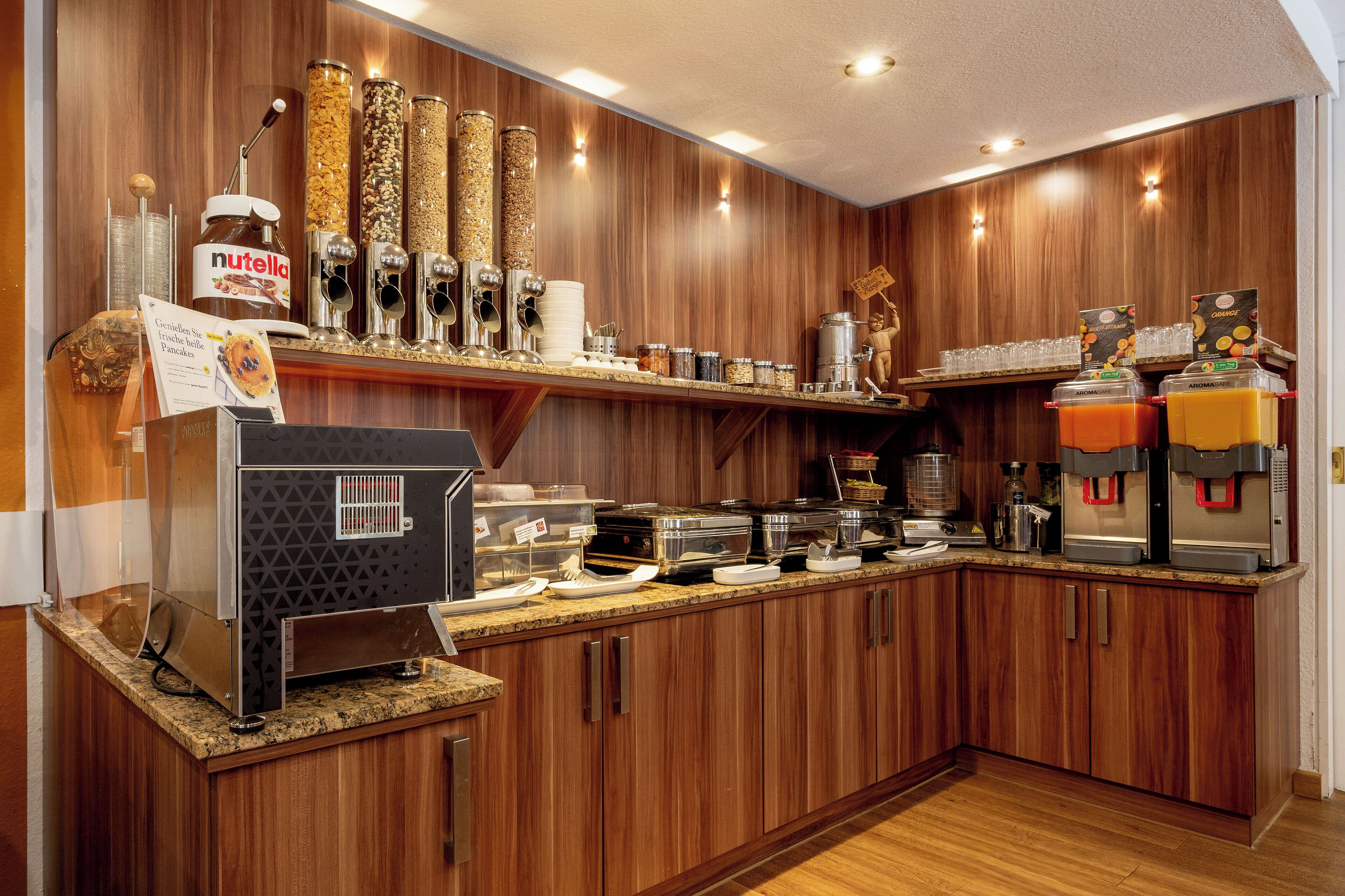 A buffet area with various food items, condiments, and beverage dispensers.