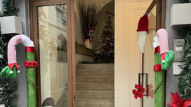 A hotel entrance decorated with Christmas ornaments, including a Santa Claus figure and candy cane decorations. - CostantiNapoli 27 (Naples)