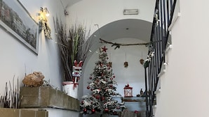 A staircase with a Christmas tree decorated with ornaments and a star on top. - CostantiNapoli 27 (Naples)