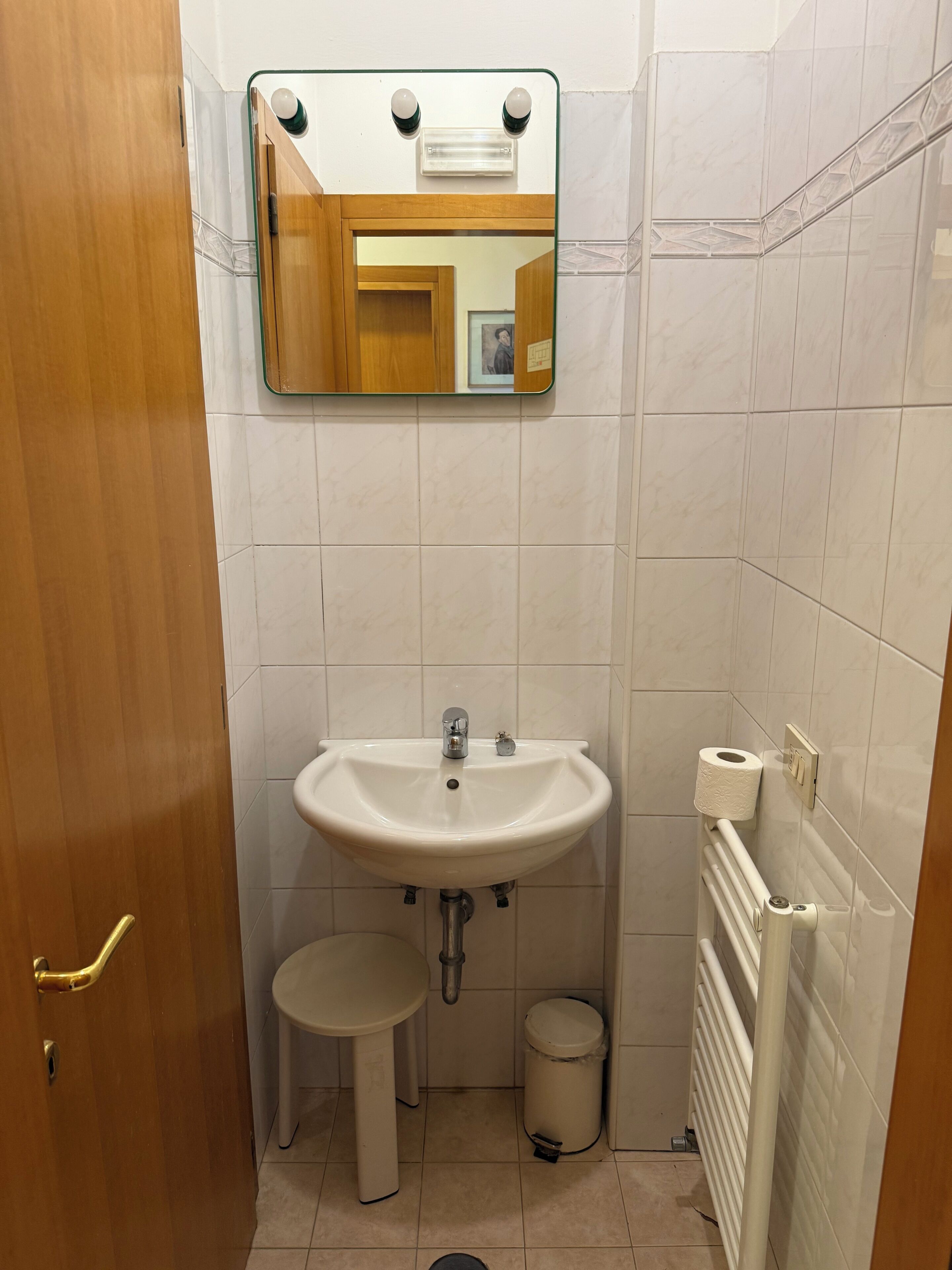 A small bathroom with a sink, toilet, and a mirror above the sink.