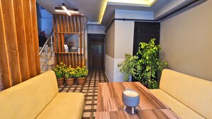 A modern interior with a wooden table, yellow sofa, and potted plants. - Sunrise Hotel (Istanbul)