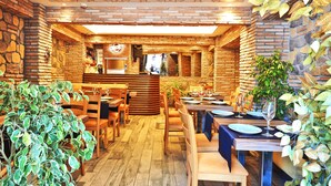 A restaurant with brick walls, wooden flooring, and tables set for dining. - Sunrise Hotel (Istanbul)