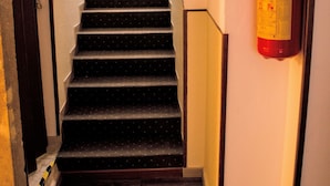 Un escalier avec un extincteur fixé au mur.