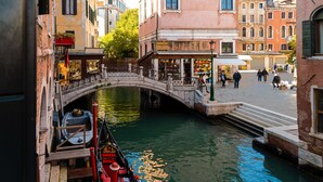 A canal with a bridge, boats, and buildings along the water. - Hotel Al Vagon (Venice)